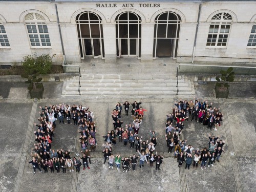 Photo aérienne réalisée par drone. Logo humain formé des collaboratrices et collaborateurs de la société D & C. Agence évènementielle Super Héraut. | Philippe DUREUIL Photographie