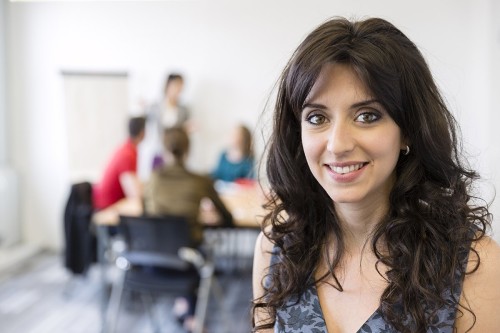 Portrait d'une femme souriante en formation. Production photo corporate réalisée pour Orsys Formation à La Défense. | Philippe DUREUIL Photographie