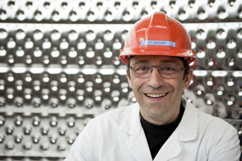 Photographie de portrait corporate d'un chercheur portant un casque de protection dans un cryostat géant. Reportage corporate réalisé au centre de recherche du CEA de Saclay. | Philippe DUREUIL Photographie