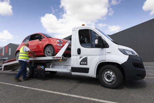 Photographie professionnelle corporate de reportage. Un opérateur arrime une Fiat 500 sur le plateau de son camion porte voiture. Client : Groupe GCA. | Philippe DUREUIL Photographie