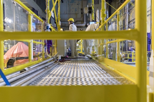 Opérateurs au travail sur une passerelle surplombant la piscine à la centrale nucléaire en démantèlement de Chooz A. | Philippe DUREUIL Photographie