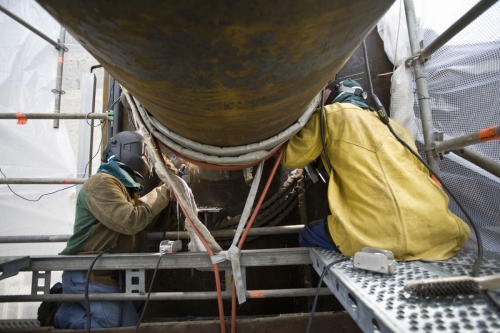 Photographie industrielle réalisée sur le site de Naval Group à Brest. Soudeurs au travail sur l'assemblage du tripode de l'hydrolienne l'Arcouest d'EDF. Agence Toma. | Philippe DUREUIL Photographie