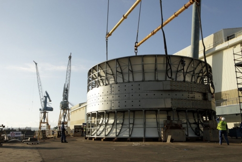 Levage de l'hydrolienne l'Arcouest à laide d'un pont roulant en vue de son déplacement.  Photographie industrielle réalisée sur le site de la société Naval Group à Brest. | Philippe DUREUIL Photographie