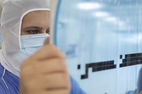 Opérateur au travail en salle blanche - Industrie du micro packaging. | Philippe DUREUIL Photographie