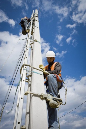 Reportage industriel réalisé pour ERDF dans un centre de formation. Photo industrielle d'hommes en formation pratique  sur un poteau béton de lignes électriques basse tension. | Philippe DUREUIL Photographie