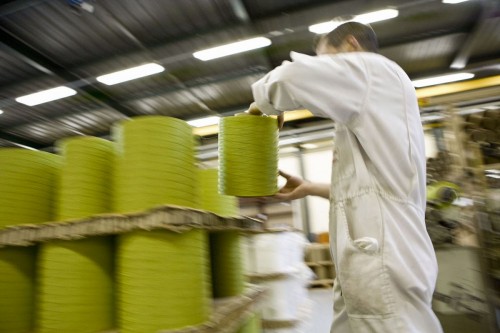 Photographie  industrielle  d'un homme en action dans un atelier de tissage. Reportage industriel réalisé pour le groupe Ferrari Textiles. | Philippe DUREUIL Photographie