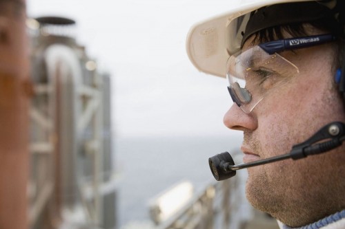 Photographie industrielle d'un opérateur sur la plate-forme offshore de Troll A en mer du nord - Reportage industriel réalisé pour GDF Suez. Homme équipé d’un casque, de lunettes de protection et d’un micro. | Philippe DUREUIL Photographie