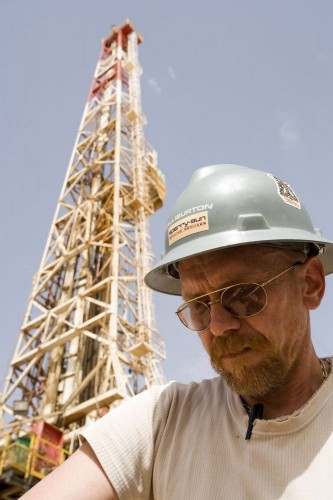 Photo industrielle d'un opérateur casqué devant un rig de forage dans le désert Algérien - Photographie industrielle réalisée pour GDF Suez. | Philippe DUREUIL Photographie