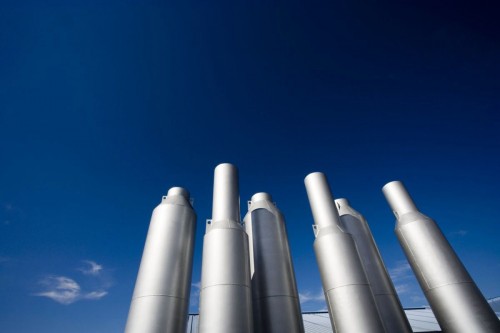 Photographie industrielle graphique de cheminées d'un site industriel sur fond de ciel bleu. | Philippe DUREUIL Photographie