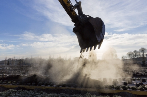 Pelleteuse en contre jour dans la lumière du matin sur le chantier de restitution des jardins à la Française du château de Chambord. | Philippe DUREUIL Photographie