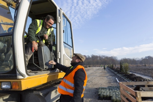 Le paysagiste Thierry Jourd'heuil salue un ouvrier aux commandes d'une pelleteuse sur le chantier des jardins du château de Chambord. | Philippe DUREUIL Photographie