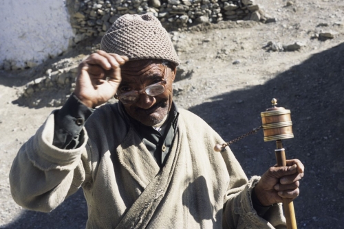 Vieil homme avec un moulin à prières dans le village de Lamayuru | Philippe DUREUIL Photographie