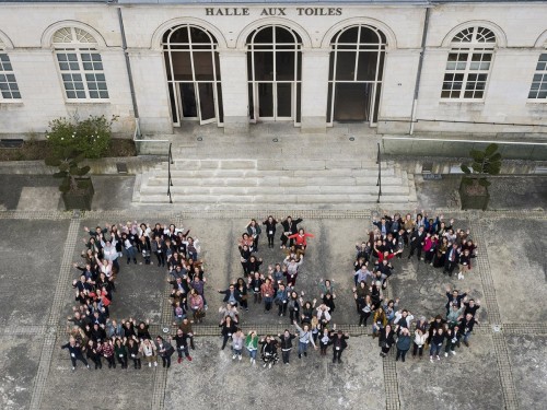 Photo aérienne par mât télescopique. Logo humain formé des collaboratrices et collaborateurs de la société D & C. Agence évènementielle Super Héraut. | Philippe DUREUIL Photographie