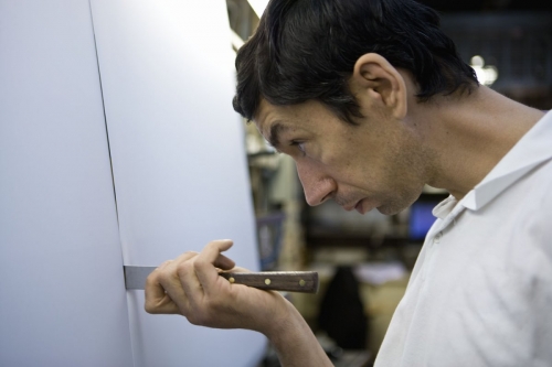 Portrait d'un opérateur au travail dans un atelier de fabrication du Groupe Serge Ferrari. Il contrôle la qualité sur une ligne de fabrication. | Philippe DUREUIL Photographie