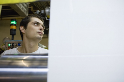 Jeunne homme au travail sur une ligne de production de tissus - Cliché réalisée pour le Groupe FERRARI TEXTILES | Philippe DUREUIL Photographie