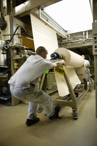 Homme au travail sur une ligne de production d'un atelier de fabrication de textiles techniques. Photographie de reportage "men at work" réalisée pour le Groupe Serge Ferrari. | Philippe DUREUIL Photographie