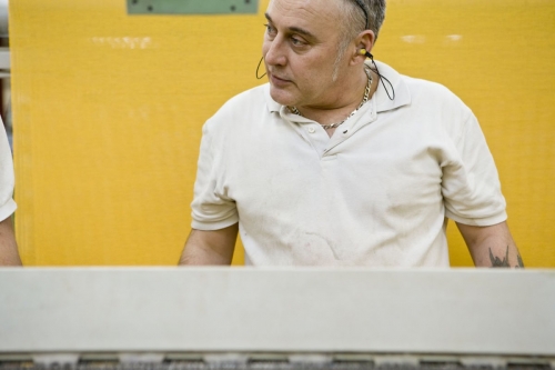 Photo d'un homme au travail dans un atelier de tissage réalisée pour le Groupe FERRARI TEXTILES | Philippe DUREUIL Photographie