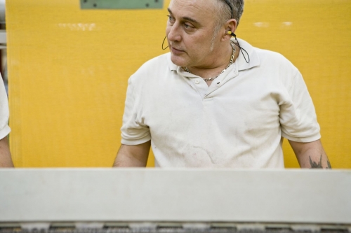 Photo d'un homme au travail dans un atelier de tissage réalisée pour le Groupe Serge Ferrari. | Philippe DUREUIL Photographie