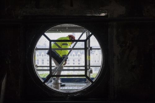 Homme équipé de ses EPI en train de se déplacer sur un échafaudage installé en extérieur. | Philippe DUREUIL Photographie