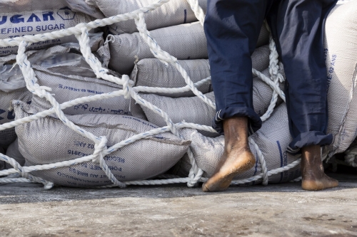 Photographique réalisée à Lomé, Togo, pour le Groupe Necotrans. Un homme est au travail pour décharger des sacs de sucre. Agence de communication : Wellcom. | Philippe DUREUIL Photographie