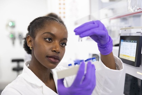 Photographie de reportage corporate en entreprise. Portrait métier d'une femme au travail dans un laboratoire du centre de recherche Rice de la société Natran. | Philippe DUREUIL Photographie
