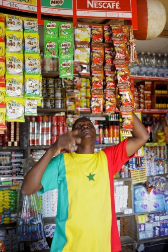 Vendeur dans sa boutique avec des produits Nescafé®. Reportage photo réalisé pour Nescafé®. | Philippe DUREUIL Photographie