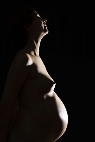 Photo artistique d’une femme enceinte en studio, silhouette à contre-jour sur fond noir | Philippe DUREUIL Photographie
