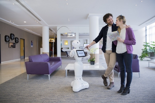 Saynète d'un couple dans le hall d'un hôtel en interaction avec Pepper. Annonceur : SoftBank Robotics. Production photo : Agence Toma. DA : Aurélien Esquivet. | Philippe DUREUIL Photographie
