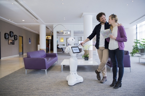 Saynète d'un couple dans le hall d'un hôtel en interaction avec Pepper. Annonceur : SoftBank Robotics. Production photo : Agence Toma. DA : Aurélien Esquivet. | Philippe DUREUIL Photographie