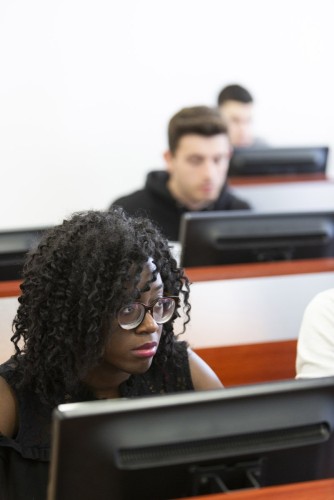 Élève  attentive en cours dans une salle de cours informatique. Client : CFA Stephenson Formation. | Philippe DUREUIL Photographie