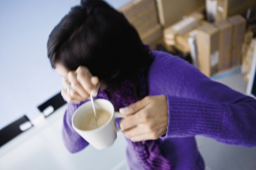 Femme qui se cache le visage au bureau avec son café | Philippe DUREUIL Photographie