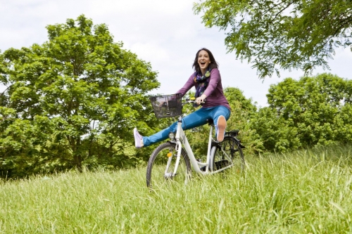 Femme qui fait du vélo sur l'herbe dans un parc de loisirs | Philippe DUREUIL Photographie