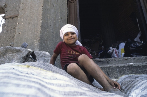 Portrait d'un jeune chiffonnier sur un tas de déchets triés | Philippe DUREUIL Photographie